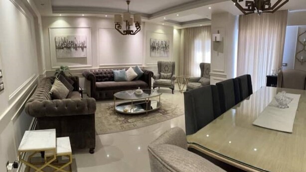 Een moderne woonkamer met een bank, salontafel en eettafel.