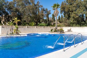 Una piscina al aire libre de temporada, sombrillas