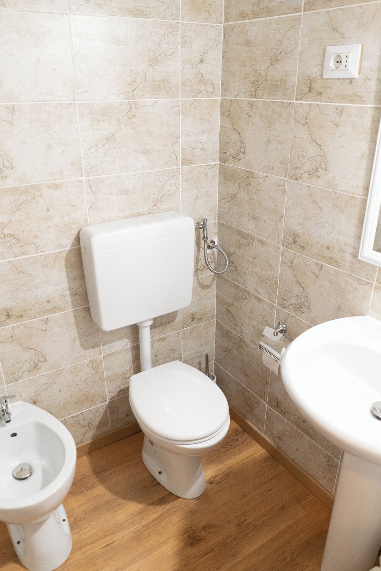 Une salle de bain équipée de toilettes, d’un bidet et d’un lavabo.