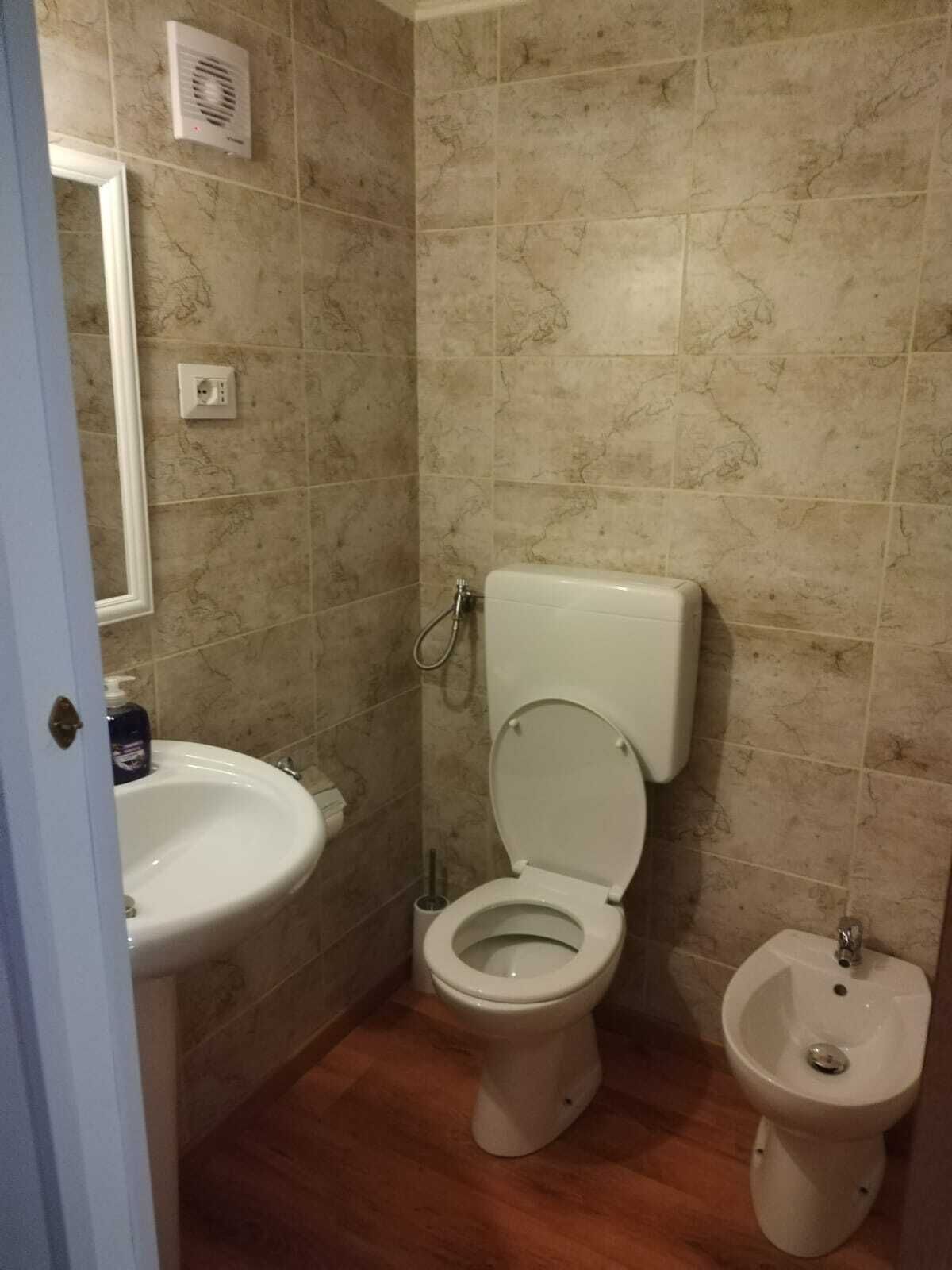 A bathroom with a toilet, bidet, and sink.