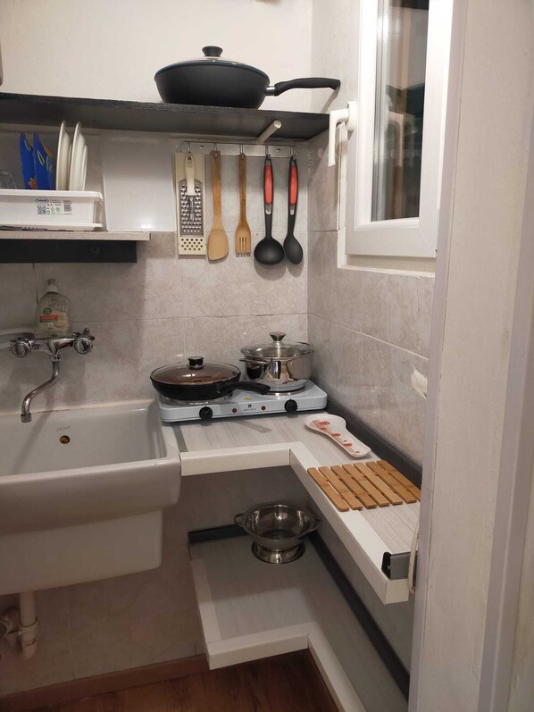 A compact kitchen with a sink, stove, and a small countertop. - La Fenice A.C. (Bologna)