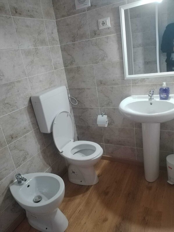 A bathroom with a toilet, bidet, and sink. - La Fenice A.C. (Bologna)