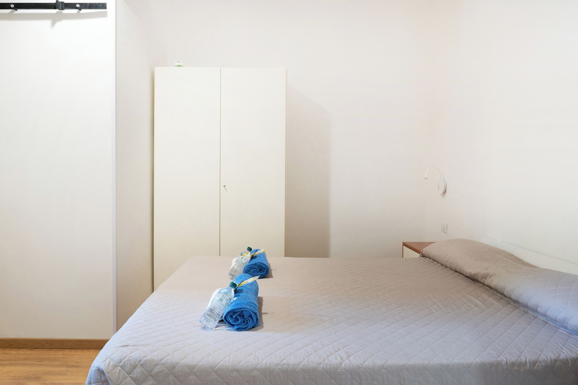 Ein Schlafzimmer mit einem Bett, einem Kleiderschrank und einem Nachttisch.