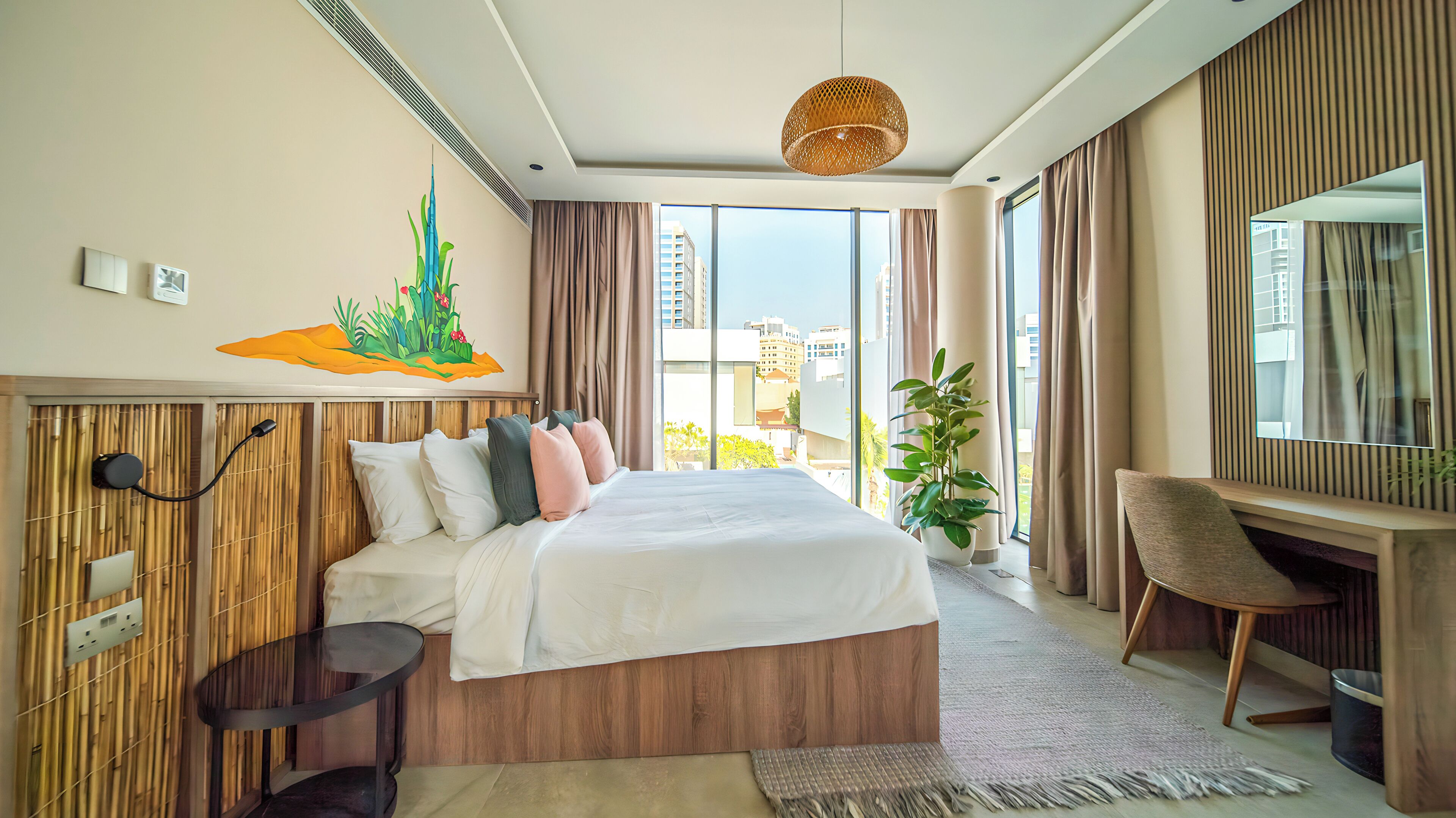 Una camera d'albergo moderna con un letto grande, una scrivania e vista sulla città.