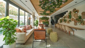 A spacious, modern interior with a wooden ceiling, large windows, and a variety of seating arrangements. - Nas House Private Villas (Dubai)