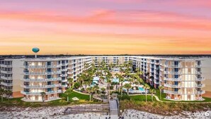 Un hôtel à plusieurs étages doté d’une cour intérieure, de balcons et d’un espace piscine.
