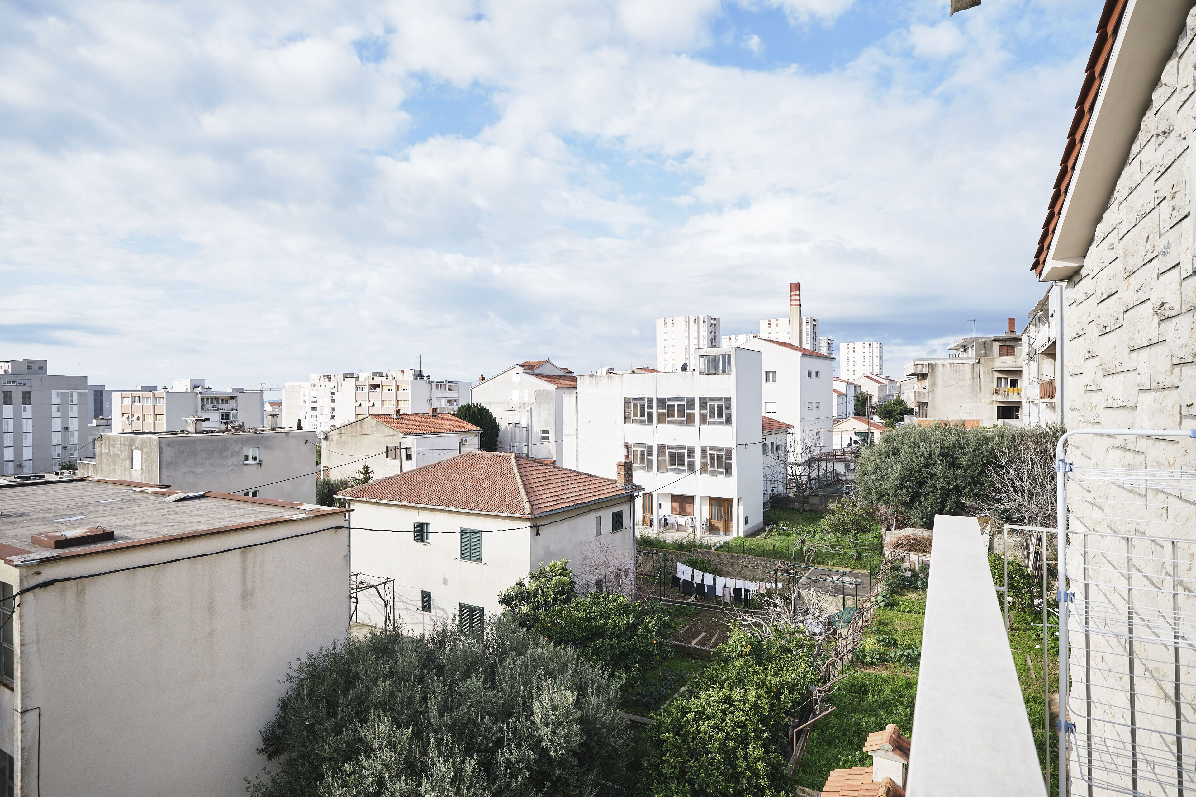 A residential area with white buildings, a garden, and a laundry line.