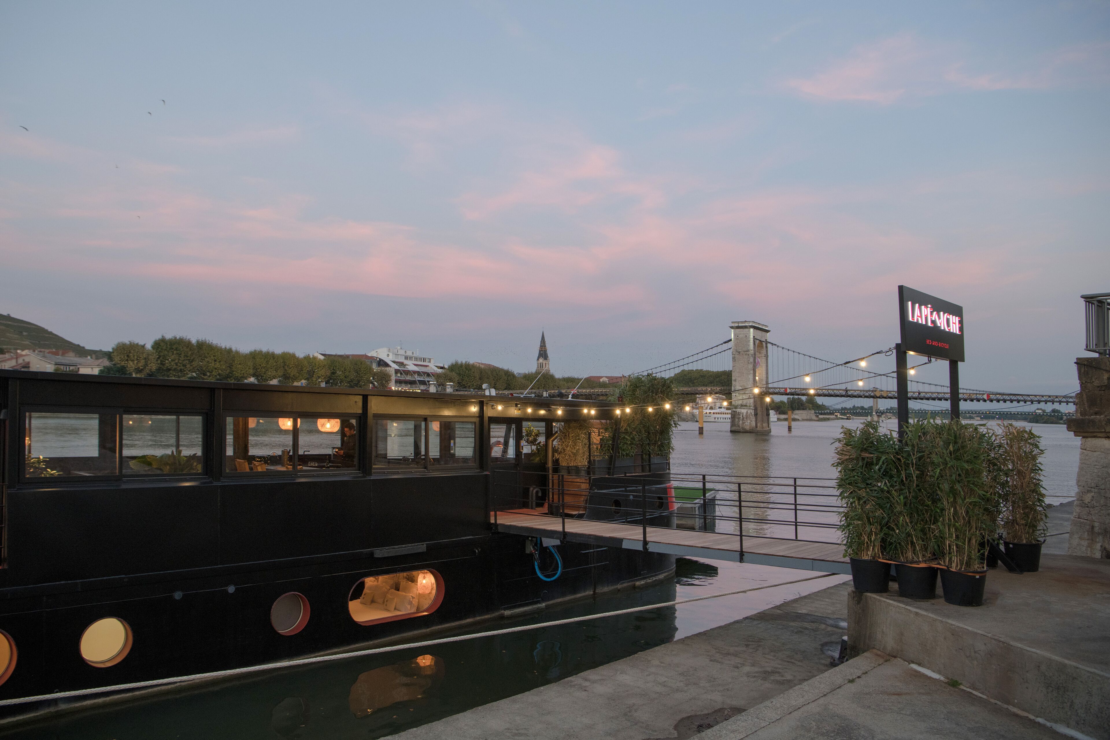 A black boat docked at a pier with a sign reading "LAPINCHÉ."