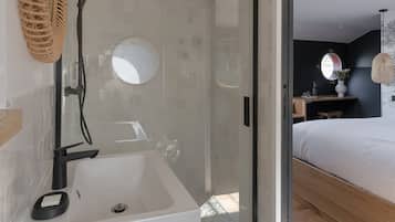 Une salle de bain moderne avec une douche à parois de verre, un lavabo blanc et un meuble-lavabo en bois.