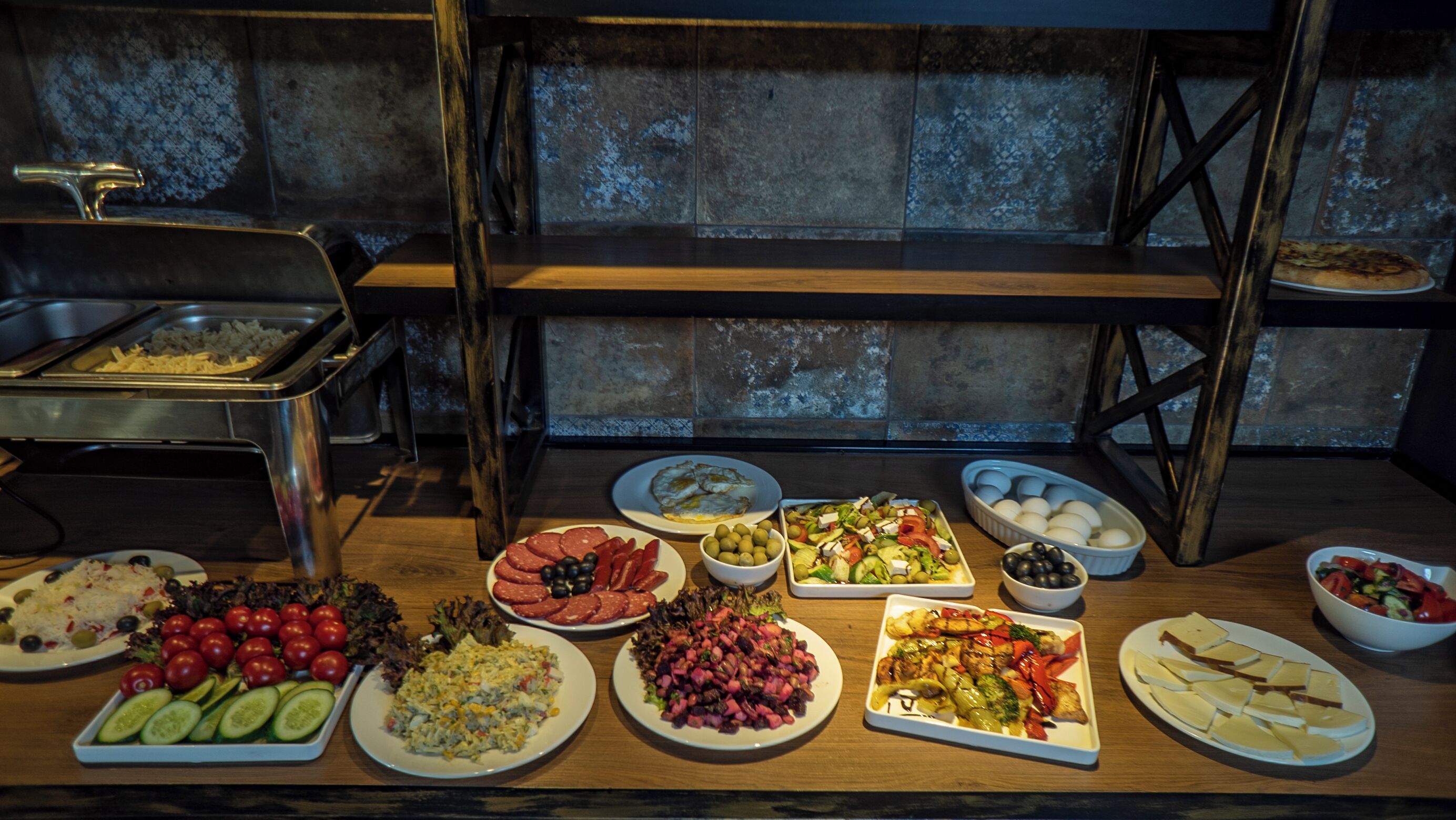 A buffet table with various dishes including salads, meats, and eggs.