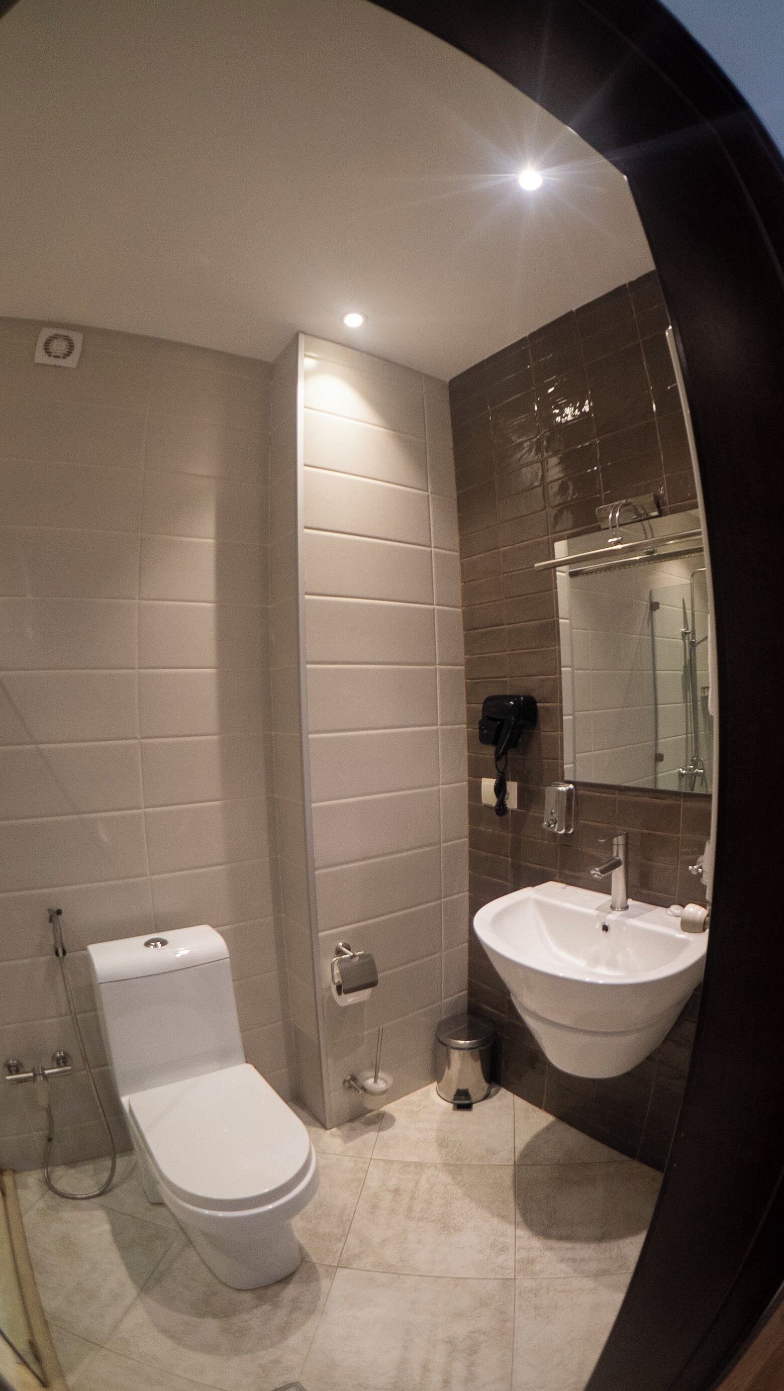 Une salle de bain moderne équipée de toilettes, d’un lavabo et d’un miroir.