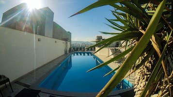 A swimming pool with a view of a cityscape in the background.