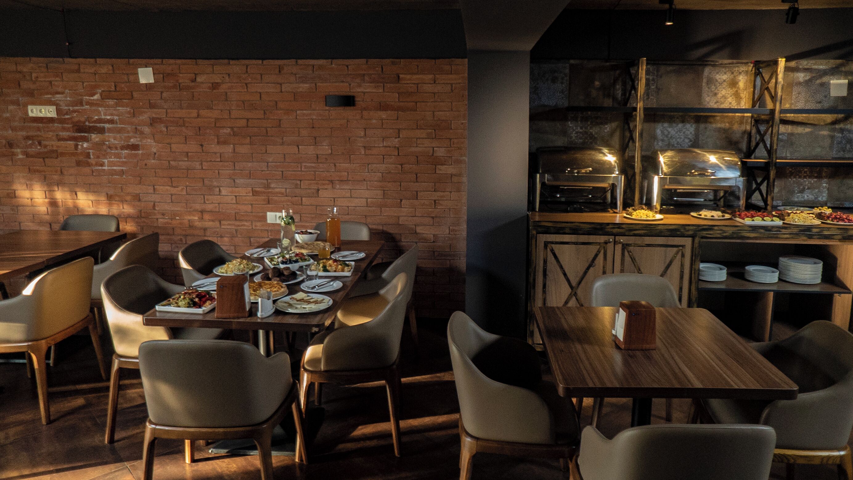 A restaurant with brick walls, wooden tables, and chairs.