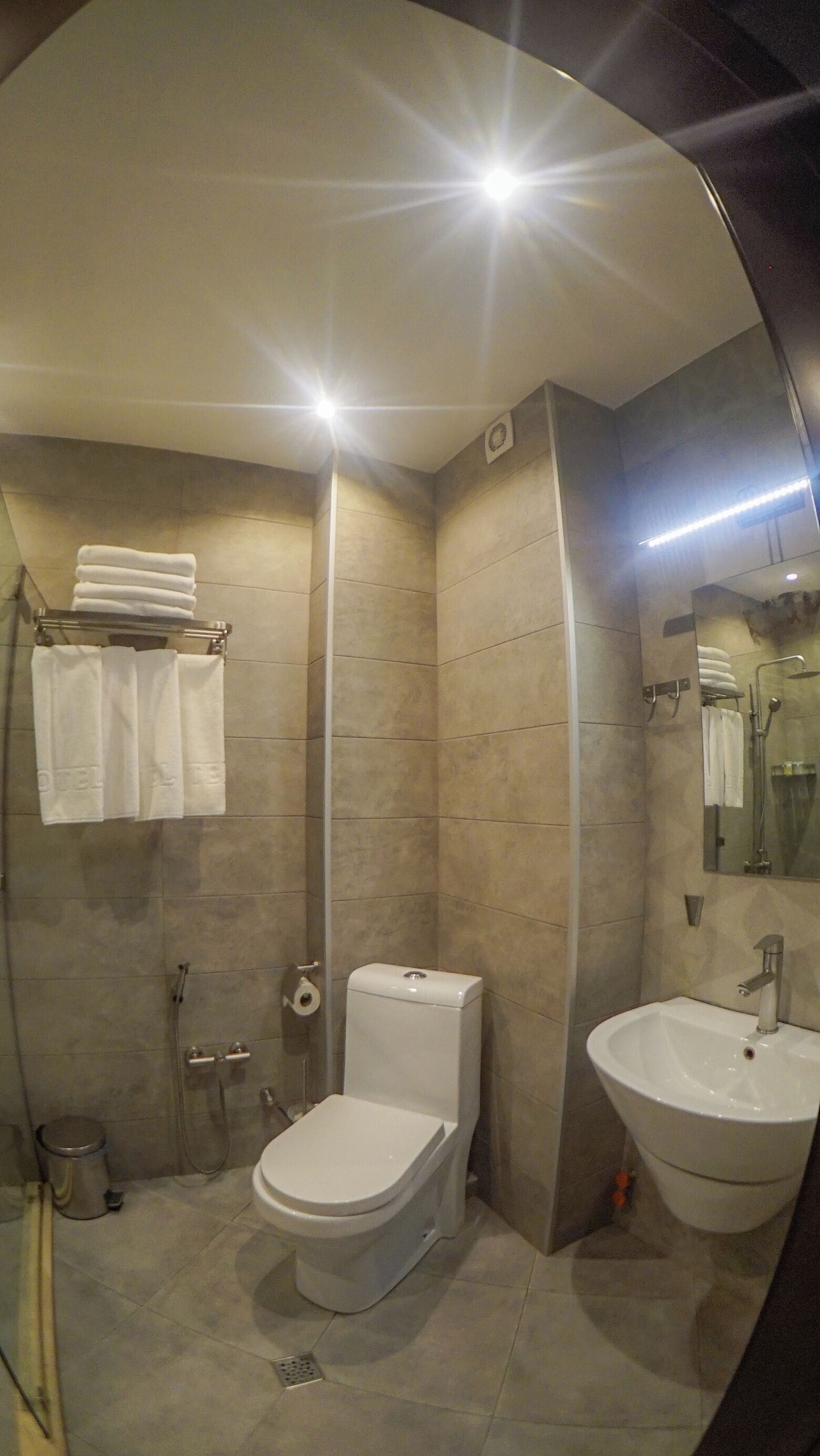 A modern bathroom with a toilet, sink, and shower.