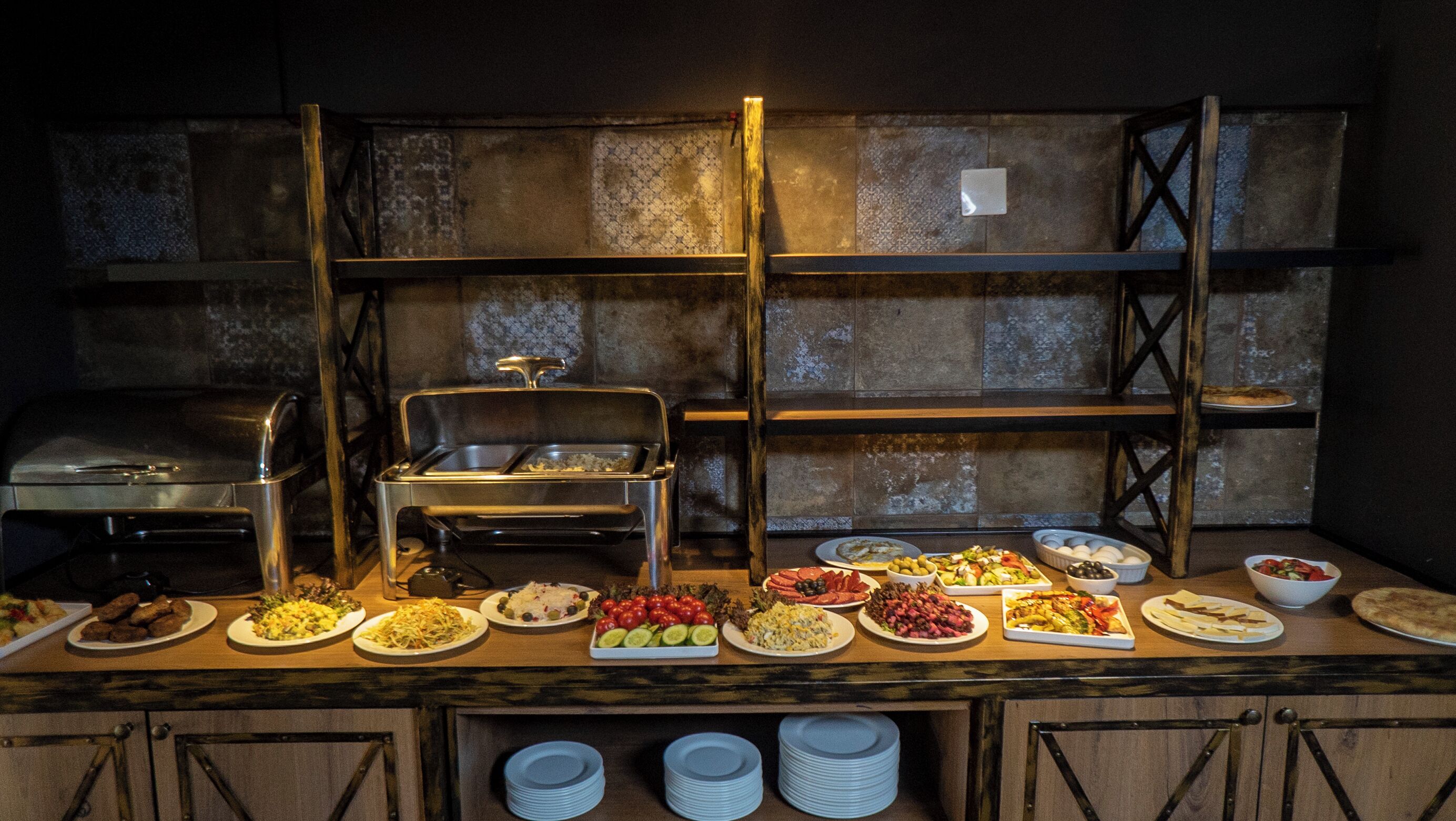 A buffet setup with various dishes and a grill.