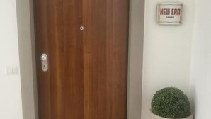A wooden door with a sign above it reading "NEW ERA Rooms". - New era Rooms  (Naples)