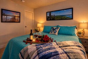A bedroom with a bed, a nightstand, a lamp, a tray with wine, roses, and a candle. - 306 - Elevator, walk to landing Gym & indoor pool (Branson)