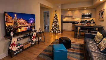 Een moderne woonkamer met een flatscreen televisie, een kerstboom en een gezellige zithoek.