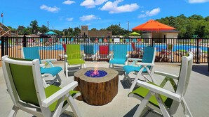 Un espace aménagé au bord de la piscine, avec des chaises longues et un foyer.