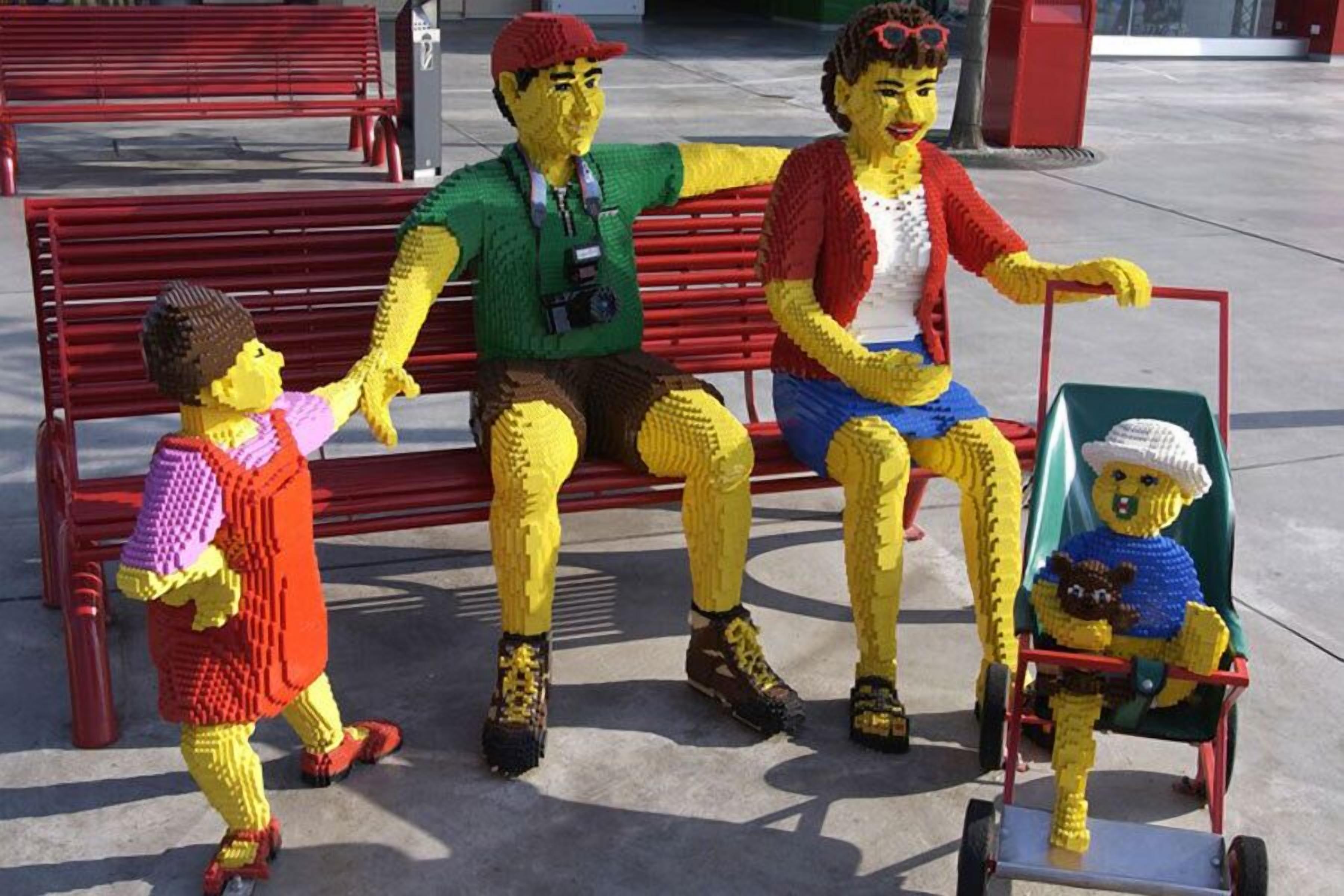 A LEGO sculpture of a family on a bench.