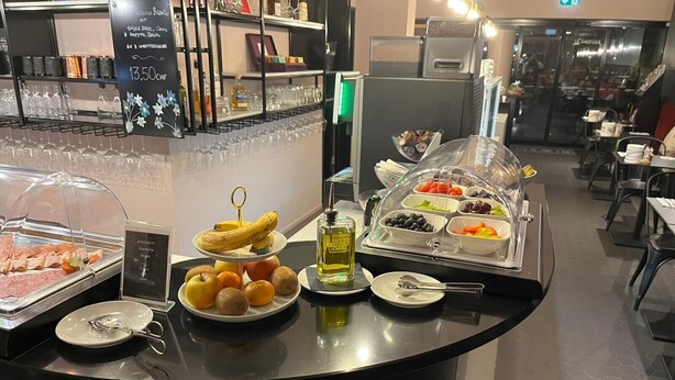A buffet counter with various food items, including sliced meats, fruits, and a selection of cheeses. - BLOOM Boutique Hotel & Lounge Basel (Basel)