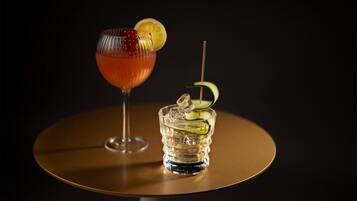 Two drinks on a round table with a dark background.