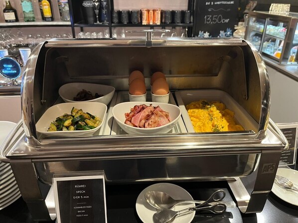 A buffet with scrambled eggs, bacon, and vegetables. - BLOOM Boutique Hotel & Lounge Basel (Basel)