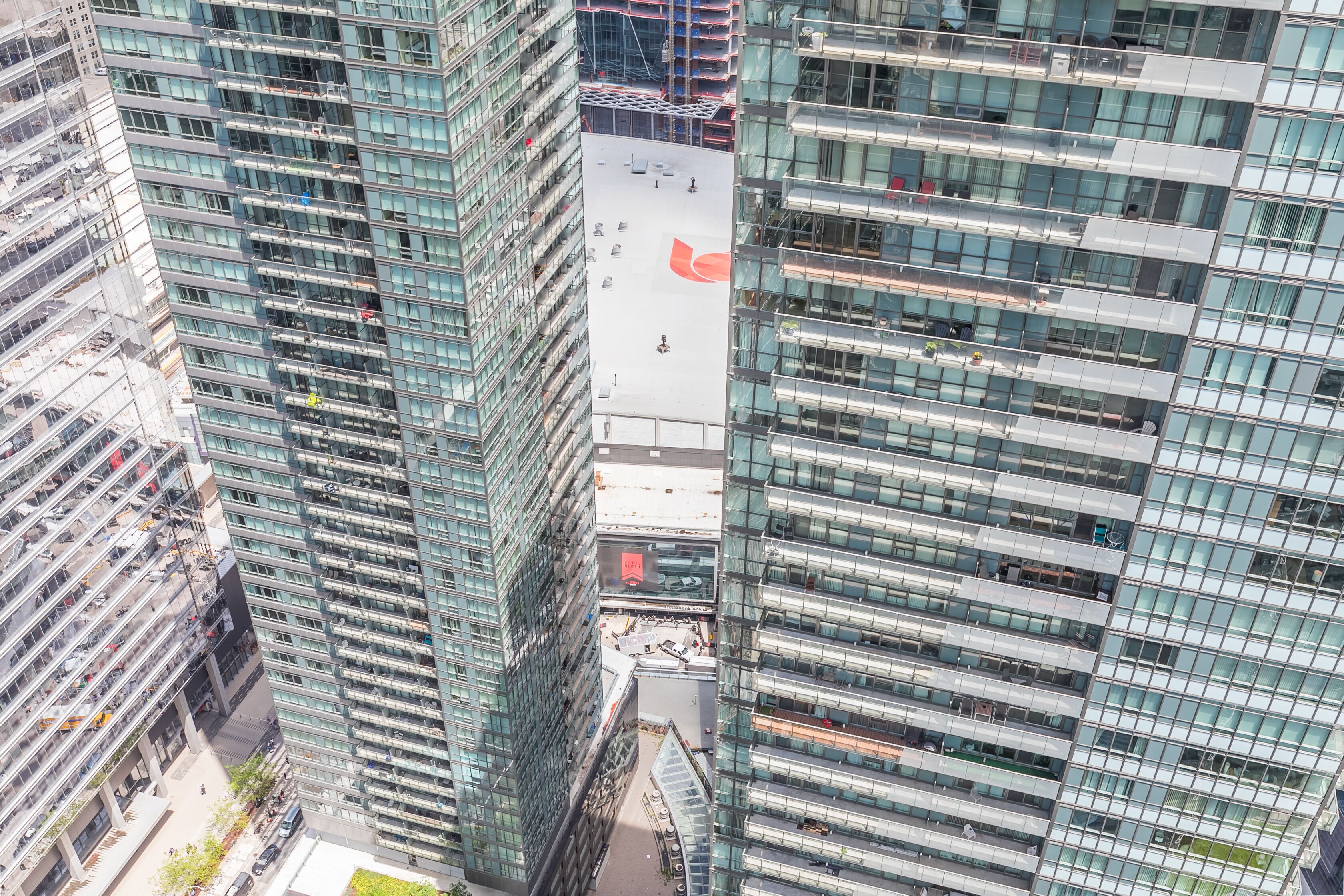 A high-rise building with a glass facade, multiple floors, and a central courtyard.
