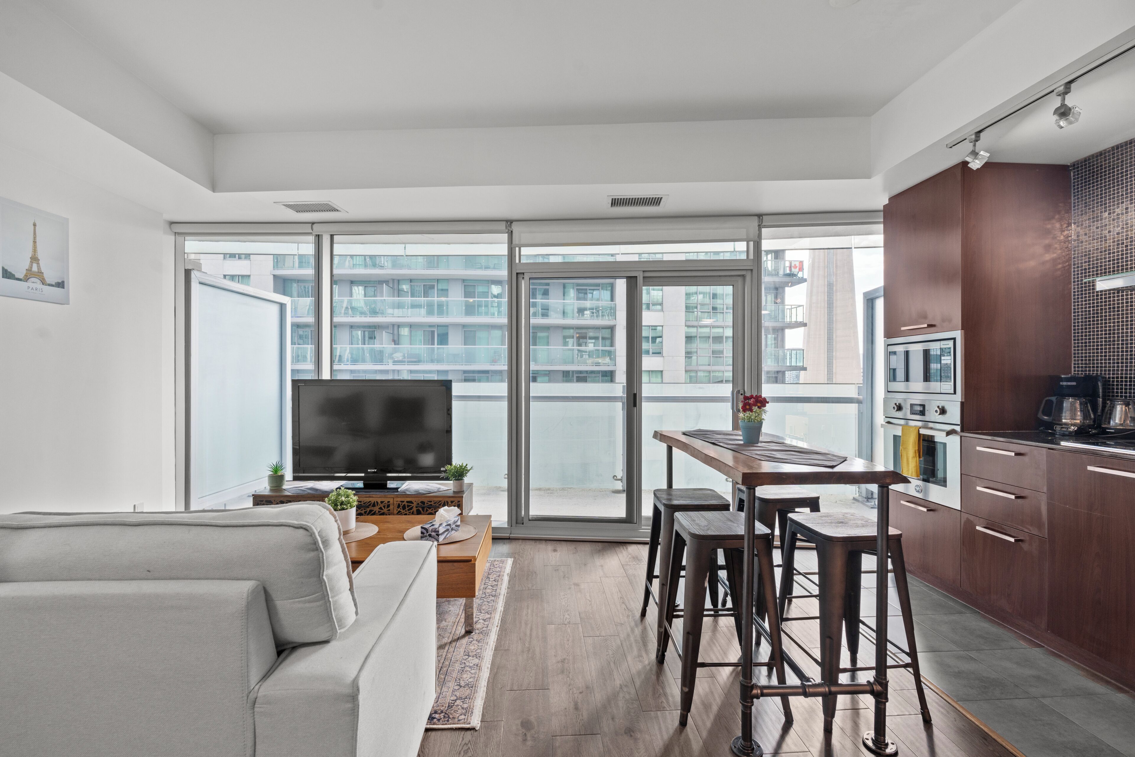 Un appartement moderne comprenant un salon, une cuisine et un balcon avec vue sur la ville.