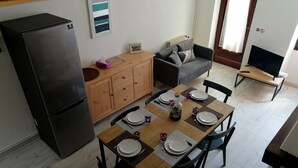 Un espacio habitable compacto con comedor, kitchenette y zona de estar.