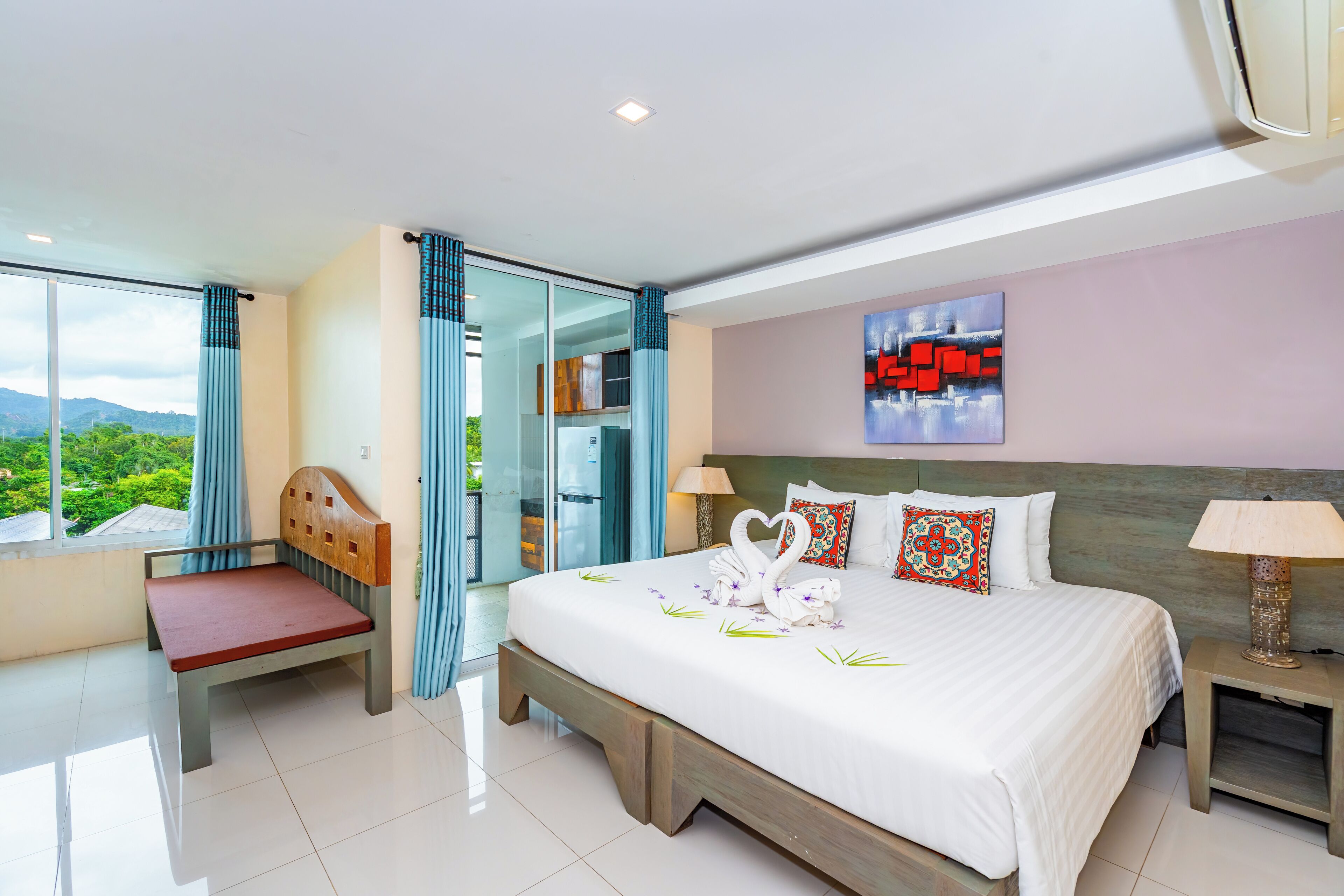 A modern hotel room with a large bed, a wooden chair, a glass door leading to a balcony, and a cityscape view.