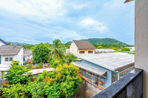 Zona residencial con casas, abundante vegetación y un paisaje montañoso al fondo.