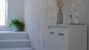 Una habitación con un armario blanco, una planta en maceta y cuadros en la pared.
