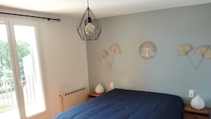 Ein Schlafzimmer mit einem großen Bett, einem Heizkörper, einem Fenster und Wanddekoration.
