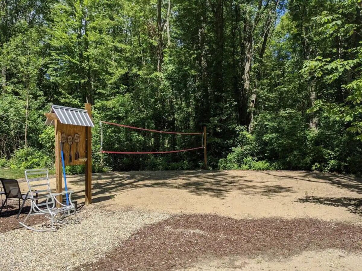 A playground with a swing set and a small wooden structure with a roof.