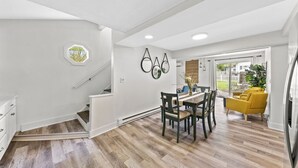 Una cocina moderna con comedor, una escalera y un sillón amarillo.