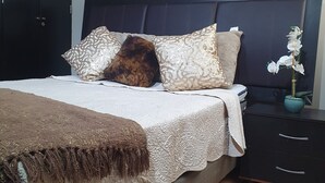 A bedroom with a bed, pillows, a bedside table, and a nightstand. - México City Luxory Apartment for 6. (Ciudad de México)