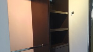 A dark brown wardrobe with multiple drawers and shelves, positioned against a white wall. - México City Luxory Apartment for 6. (Ciudad de México)
