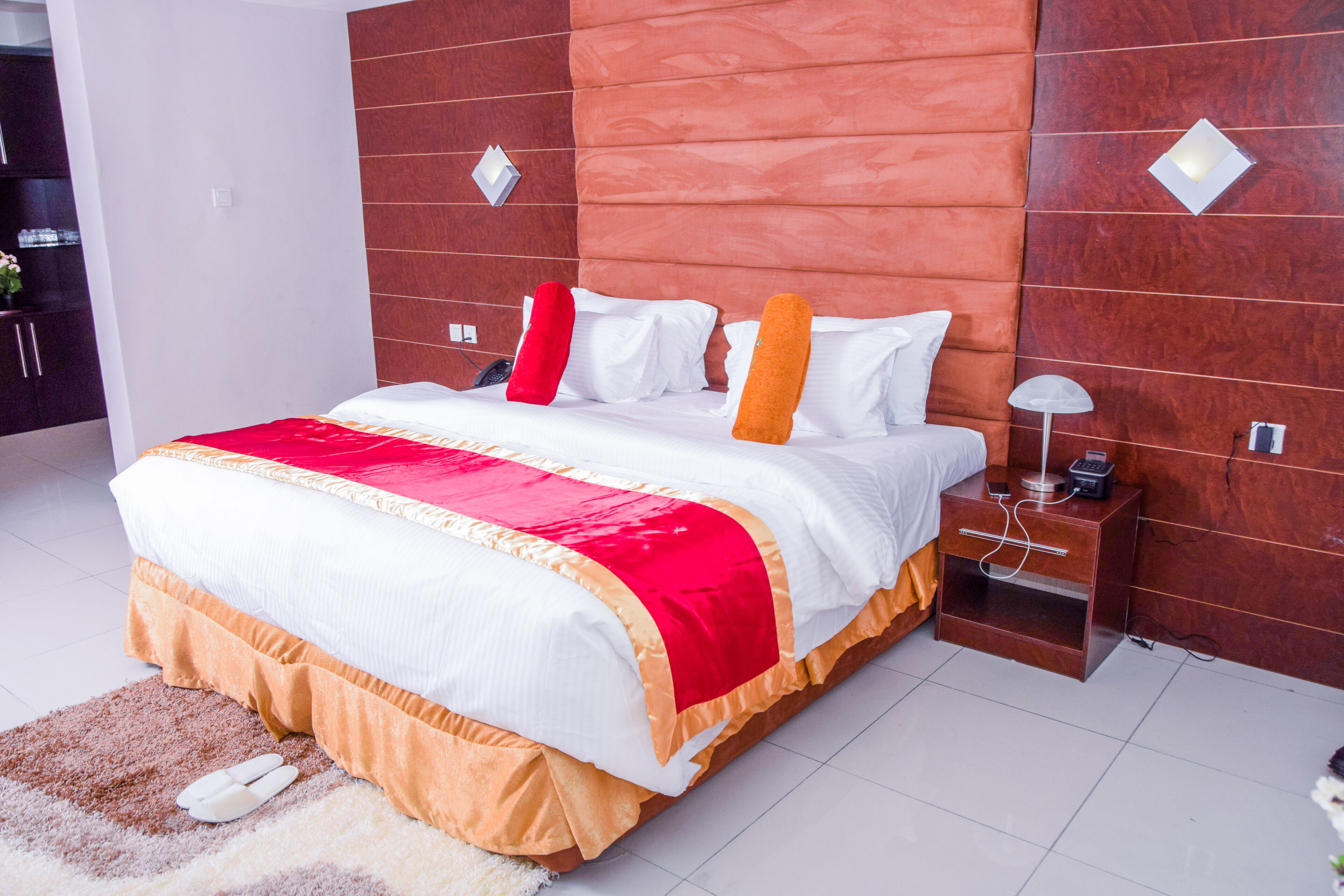 Una camera da letto moderna con un letto grande, un comodino e una testiera in legno.