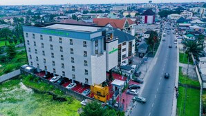 Ein Hotel mit modernem Design, mehreren Etagen und einem Parkplatz.