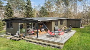 A modern house with a deck, outdoor seating, and a garage. - 3 bedroom nice home in Vig (Vig)