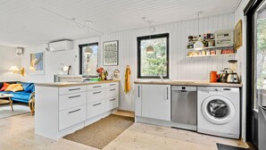 A modern kitchen with white cabinetry, a built-in washing machine, and a large window. - 3 bedroom nice home in Vig (Vig)