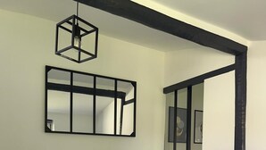 Une chambre à coucher avec un lit, un luminaire suspendu et un miroir au mur.