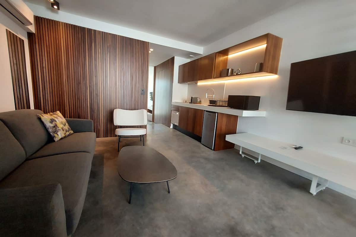 A modern living room with a sofa, a coffee table, and a TV.