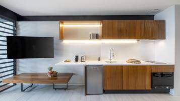 Een moderne keuken met houten kastjes, een inbouw vaatwasser en een flatscreen televisie aan de wand.