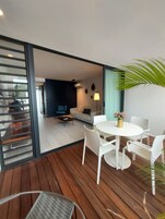 Una sala de estar moderna con un sofá, una mesa de centro y un comedor con una mesa y sillas.