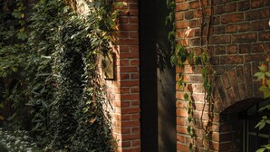A brick building with ivy and flowers. - Wilmina Apartments & Lofts (Berlin)