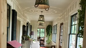 A hallway with a patterned rug, a bench, and a hanging light fixture. - Luxury Lake Rabun Cabin - restored lakefront w/ stunning views fr/every room! (Lakemont)