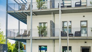 A multi-story building with balconies, outdoor seating, and a swimming pool. - Hotel Csopak Resort & Lake (Csopak)
