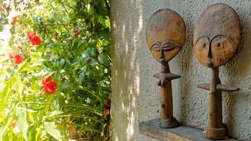 Two wooden sculptures on a shelf against a textured wall.